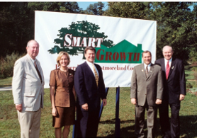 Smart Growth founders in front of a log banner